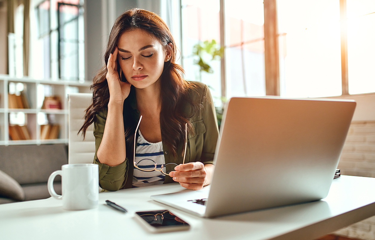 female employee on a desk experiencing listener fatigue due to poor-quality or inconsistent audio